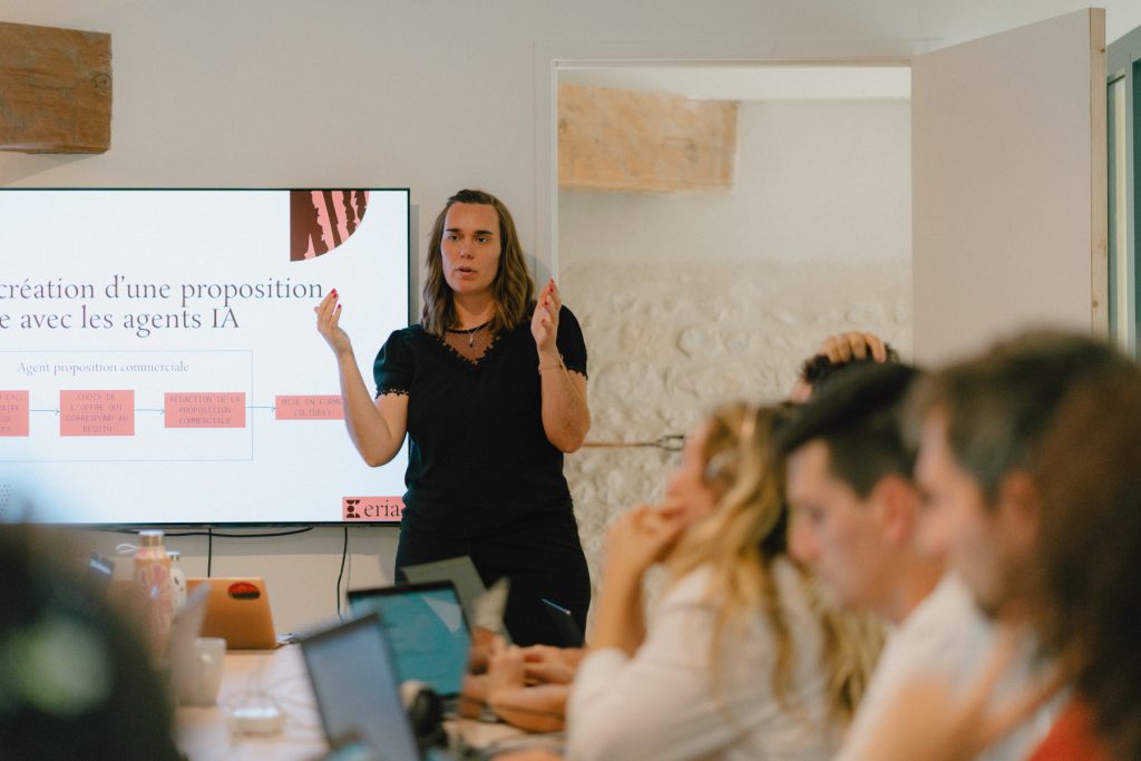 Photo de Tifany, cofondatrice d'Eria, devant une diapositive, qui explique à une équipe comment créer une proposition commerciale avec les agents IA